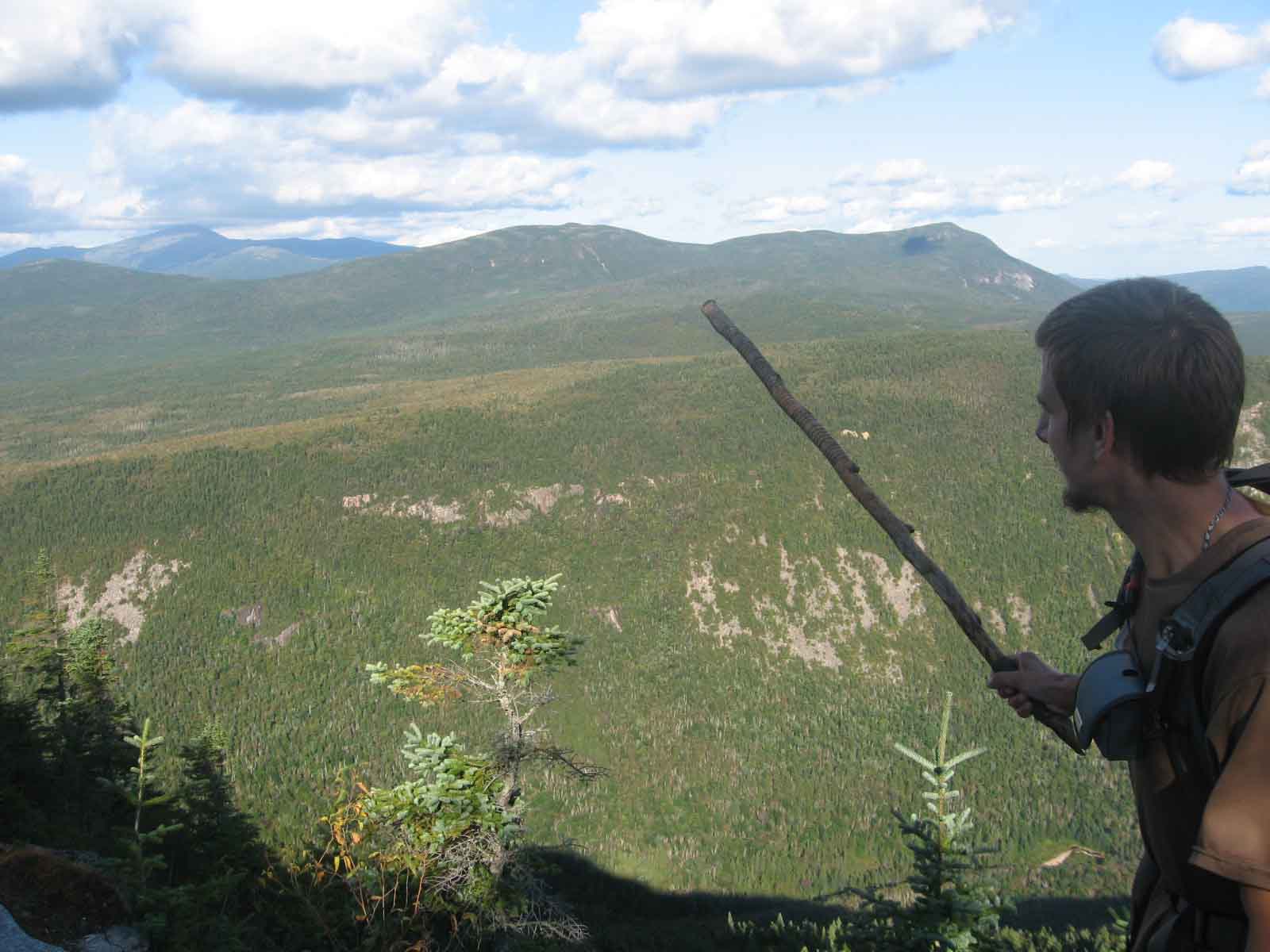 Turok pointing out Mount Washington in the distance with his hiking stick.